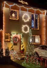 Christmassy kitschy illuminated façade of a row house in Gelsenkirchen-Ückendorf in the evening,