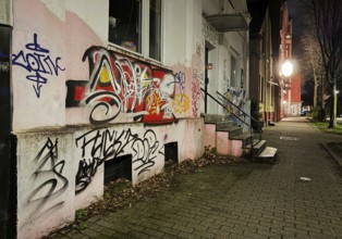 Facade covered with graffiti at night in a problem district, no-go area in Gelsenkirchen, one of