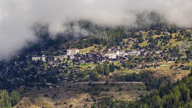 Fog is gathering over the mountain village of Saint-Luc, Val d'Anniviers, Valais Alps, Canton of
