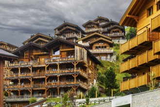 Dark clouds over wooden holiday homes, Grimentz, Val d'Anniviers, Valais Alps, Canton of Valais,