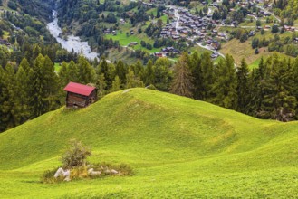 Small alpine hut on a green hill, behind the village of Mission, Val d'Anniviers, Valais Alps,