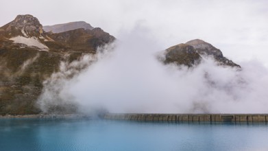 Fog rises over the dam of the Lac de Moiry Reservoir, Val d'Anniviers, Valais Alps, Canton of