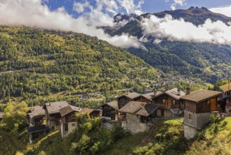 Old farmhouses in Pinsec, fog rising behind in the Val d'Anniviers, Valais Alps, Canton of Valais,