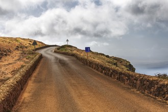 Secluded road along a rocky coast under a cloudy sky, Haria Lanzarote, Canary Island