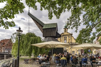 Beer garden at the Old Harbour with crane and hotel department store in the Hanseatic city of