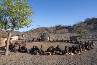 People sitting in a circle, traditional Himba village, Kaokoveld, Kunene, Namibia
