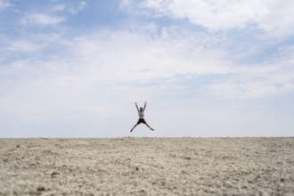 Abstract, man jumping on the Etosha pan, salt pan, Etosha National Park, Namibia