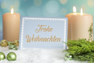Greeting card with the inscription FROHE WEIHNAHCHTEN between Christmas accessories with bokeh in