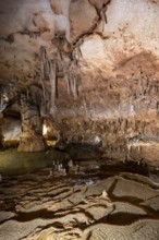 Stalactites and stalagmites, rock formations in a stalactite cave with water basin, Grotta del