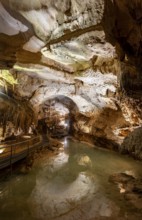 Stalactites and stalagmites, reflection in a small underground lake, rock formations in a