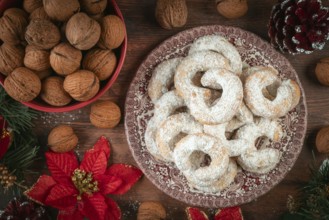 Vanilla croissants on a plate next to walnuts and Christmas decoration