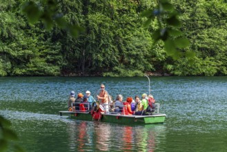 Manually operated ferry with ferryman and passengers, Lake Schmaler Luzin, Feldberg Lake District,