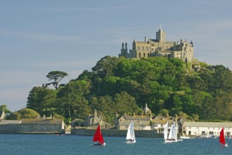 A castle overlooks the sea surrounded by sailing boats and green nature, Penzance, Saint Michael's
