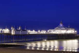 An illuminated pier stretches across the calm sea at night, Bournemouth, England, Great Britain