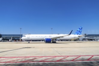 Modern passenger airplane parked on the tarmac at a bustling airport, preparing for its next flight