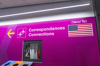 Bright pink airport sign with airplane icons and the flag of the united states of america, guiding