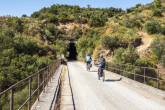 Couple riding bicycle, bridge Viaducto de Gillete, cycle path Via Verde de la Sierra, Puerto