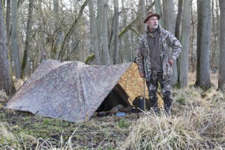 Camp of a nature photographer, nature photographer in front of his camouflage camp in the
