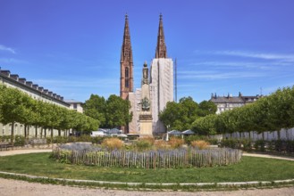 Park, round flower bed, plants, wooden fence, Waterloo monument, St. Boniface Catholic Church,