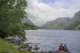 Couple sitting at Loch Beagh, Glenveagh National Park, Cross Roads, County Donegal, Ireland