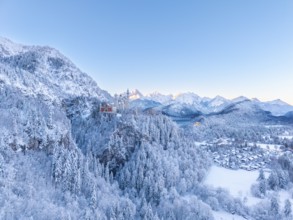 Neuschwanstein Castle is nestled in a quiet, snow-covered alpine landscape at dawn, Schwangau near