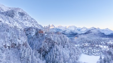 The picturesque Neuschwanstein Castle in winter surrounded by snow-capped mountains and forests at