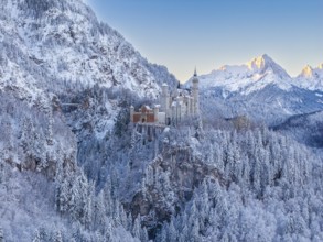 Neuschwanstein Castle against a wintry alpine backdrop in early morning light, Schwangau near