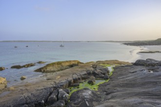 Granite rocks in the evening light and turquoise blue sea at Gurteen Beach, Roundstone, County