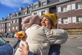 Happy mother and child sharing an affectionate hug while standing on a city street, enjoying a