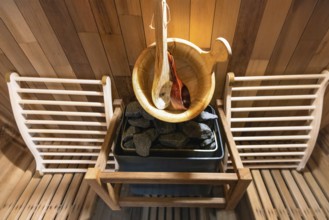 Steam and hot stone wooden cedar compact sauna interior with heating stone electrical device, hot