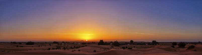 A calming sunrise over the desert that makes the sky shine in vivid colors, Sahara in Morocco