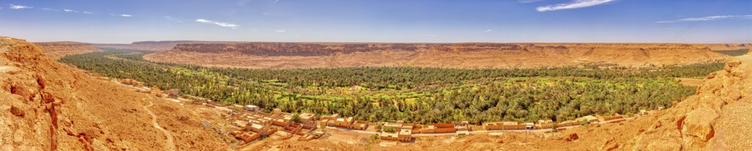 A panorama with an expansive green oasis and surrounding desert hills, Ziz Canyon in Morocco