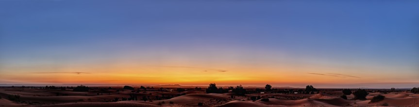 A wide panorama of the desert at sunrise with a calm, colorful sky, Sahara in Morocco