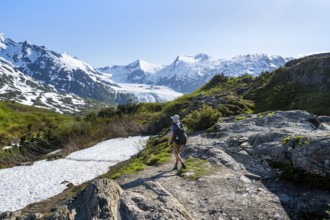 Hikers on the Portage Pass Trail, snow-covered mountains and Portage Glacier glaciers, near