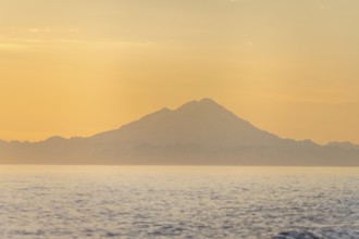 View of Cook Inlet on white mountain peaks of Mount Redoubt at sunset, midnight sun, Aleutian