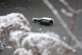 Symbolic picture of garbage in nature, bottle on frozen lake, winter, Germany
