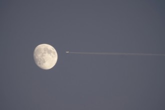 Airplane and moon, winter evening, Germany