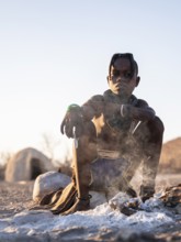 Himba child at the fire early in the morning, traditional Himba village, Kaokoveld, Kunene, Namibia