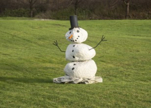 Snowman on green lawn at green winter in Ystad, Skåne County, Sweden, Scandinavia