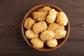 Fried crispy Chicken Nuggets on brown wooden background. top view, flat lay, copy space