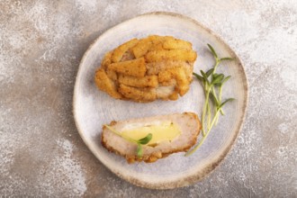 Chicken schnitzel on blue plate with microgreen on brown concrete. Diet, healthy eating. top view,