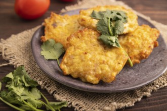Fried crispy Chicken pancakes on brown wooden background and linen textile. side view, close up,