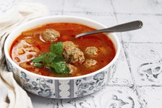 Romanian soup with meatballs, vegetable soup with meatballs, tiled table, homemade, no people