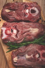 Raw steak, calf's neck on the bone, fresh meat, on the cutting board, top view, no people