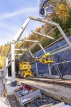 Construction work at a tunnel entrance in autumn with yellow construction equipment and visible