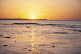 Sunrise over Jervis Bay — View of Point Perpendicular lighthouse. A ship on the horizon