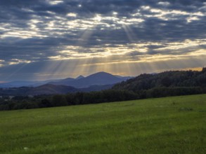 Sunbeams over gentle mountain landscape and meadows, Bohemia, Lusetian Mountains, Czech Republic