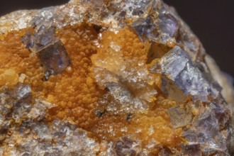 Shiny crystals of blue and orange color can be seen in this mineral formation. They are sparkling