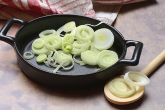 Leeks, leek rings in pan with cooking spoon, leek