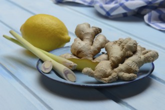 Ginger tubers with lemongrass on plate, lemon